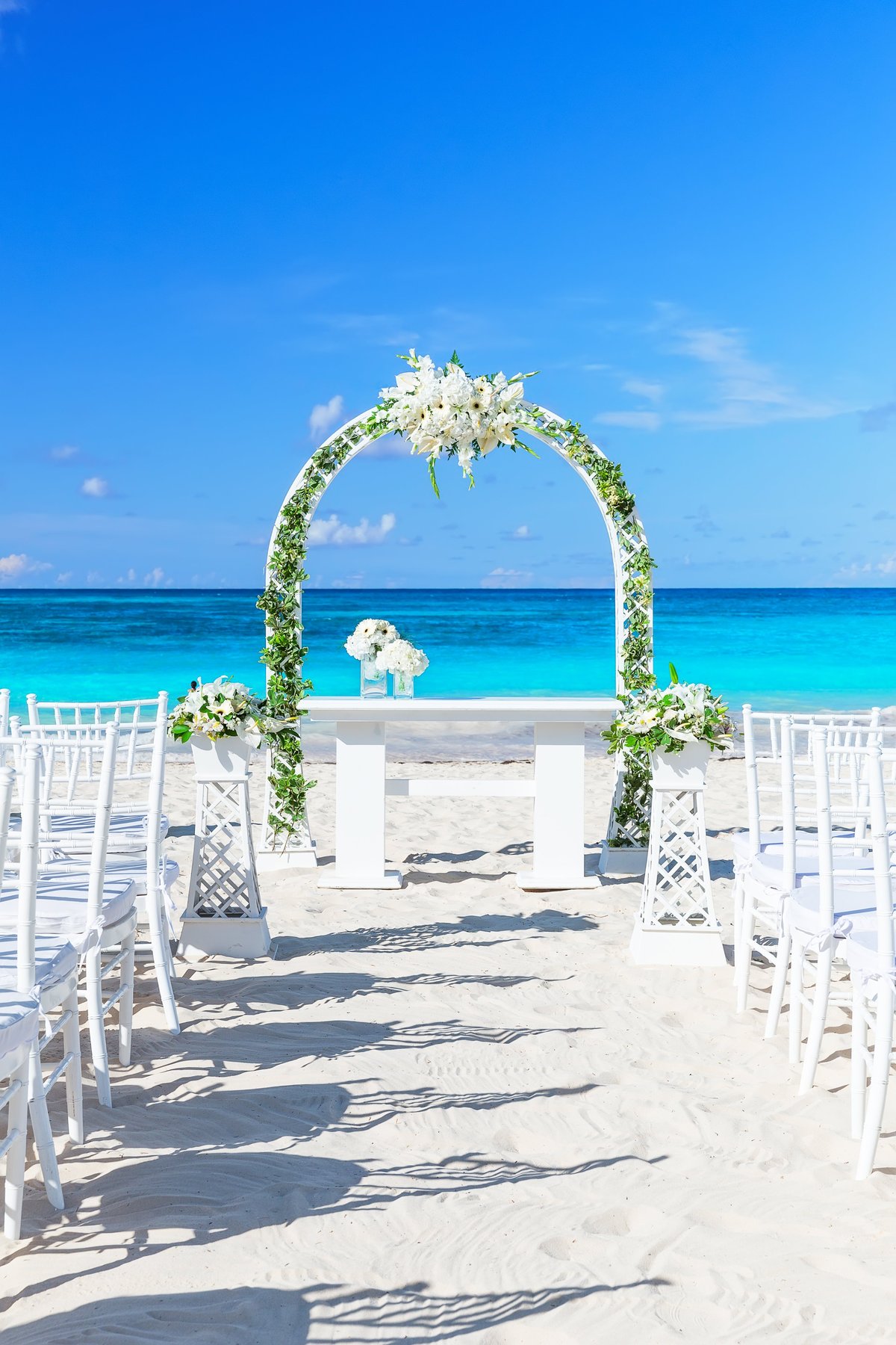 Tropical paradise wedding setting and beautiful wedding arch on the beach in Punta Cana, Dominican Republic.