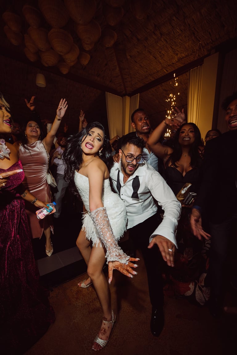 Group of people dancing at an indoor party with warm lighting and decorations