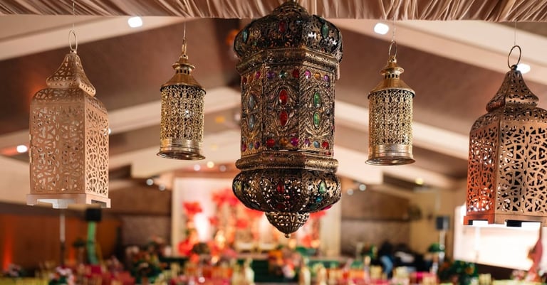 Ornate hanging lanterns with intricate metalwork suspended from ceiling in warm interior space with blurred background