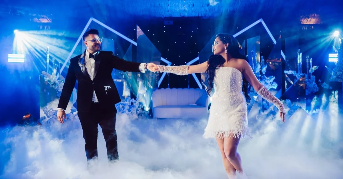 Couple dancing together on stage with dramatic blue lighting and fog effects in background